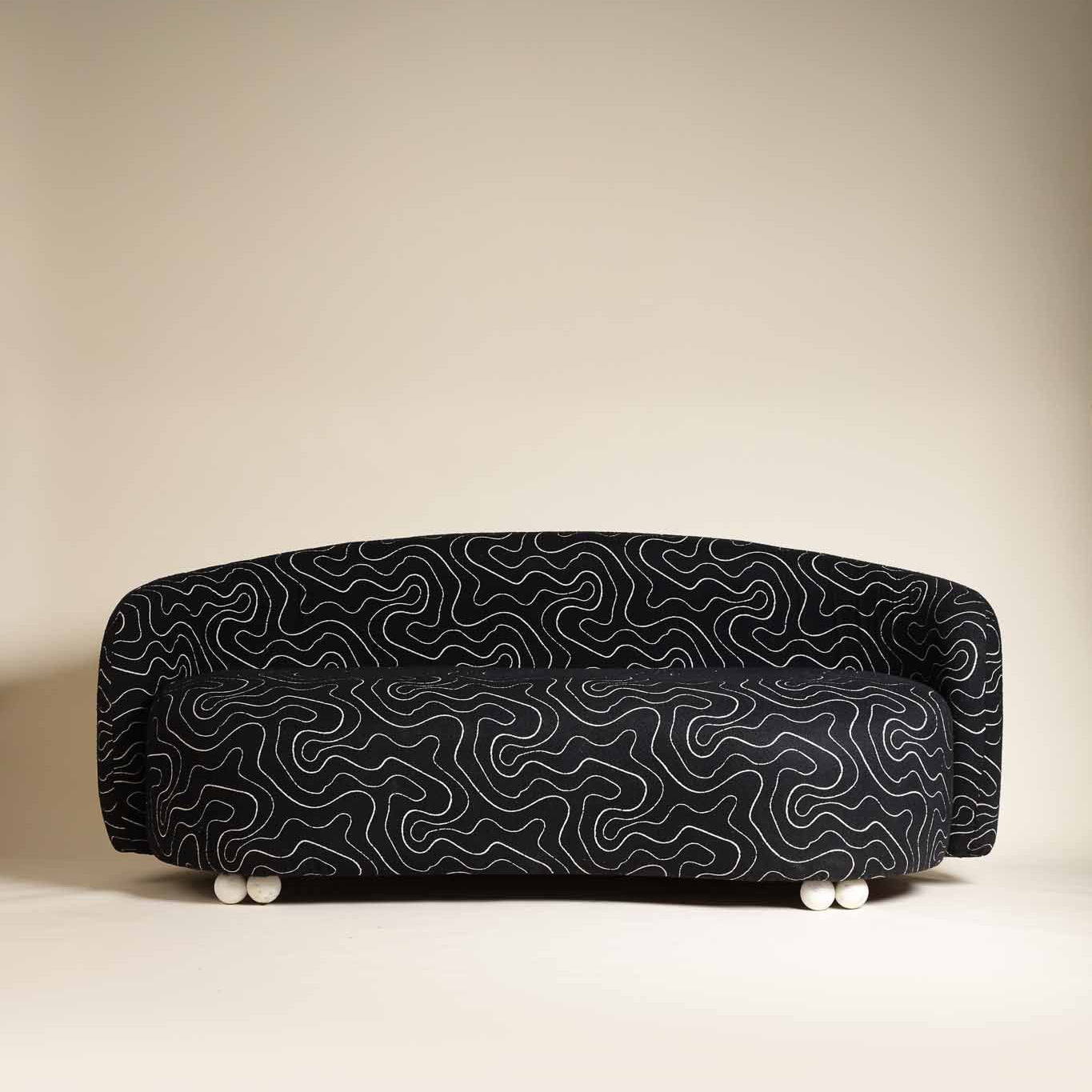 Black wavy-patterned sofa on a beige background